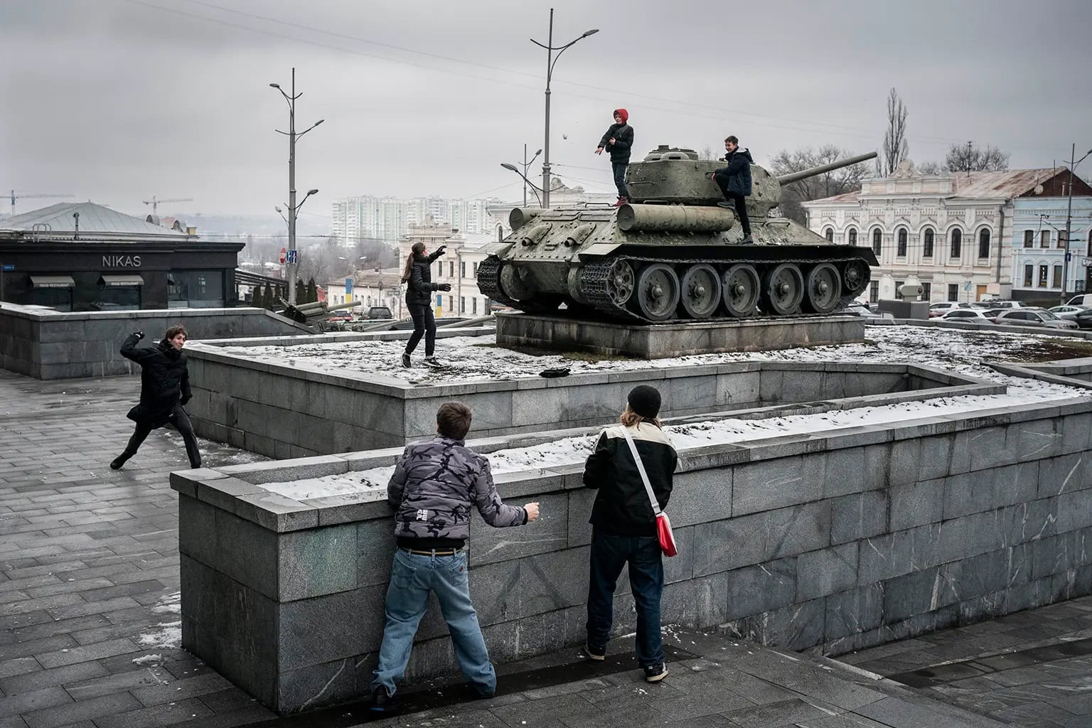 Kinder spielen auf einem Panzer in der Stadt