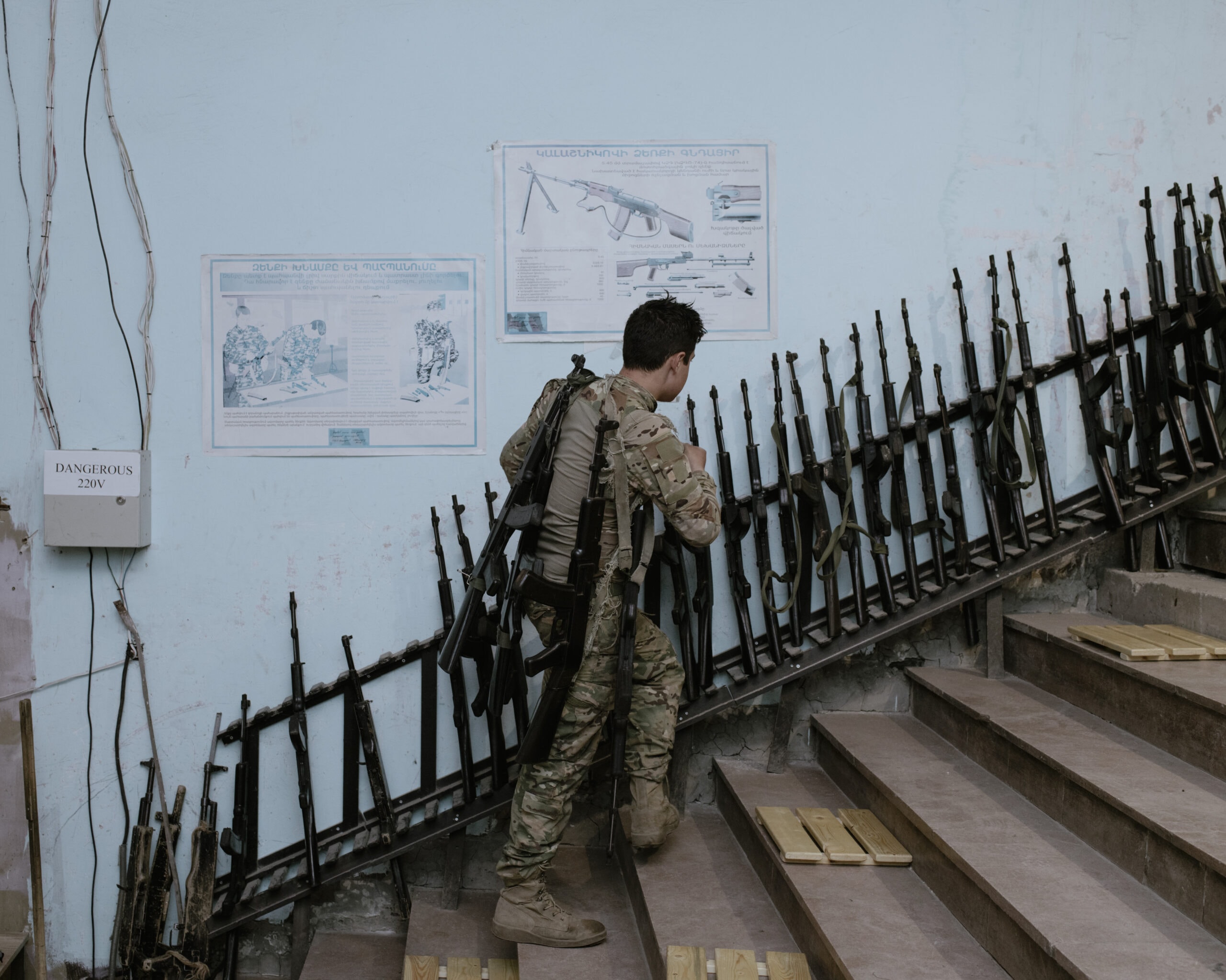 Ein Soldat läuft eine Treppe nach oben. Sie ist gesäumt von Gewehren.