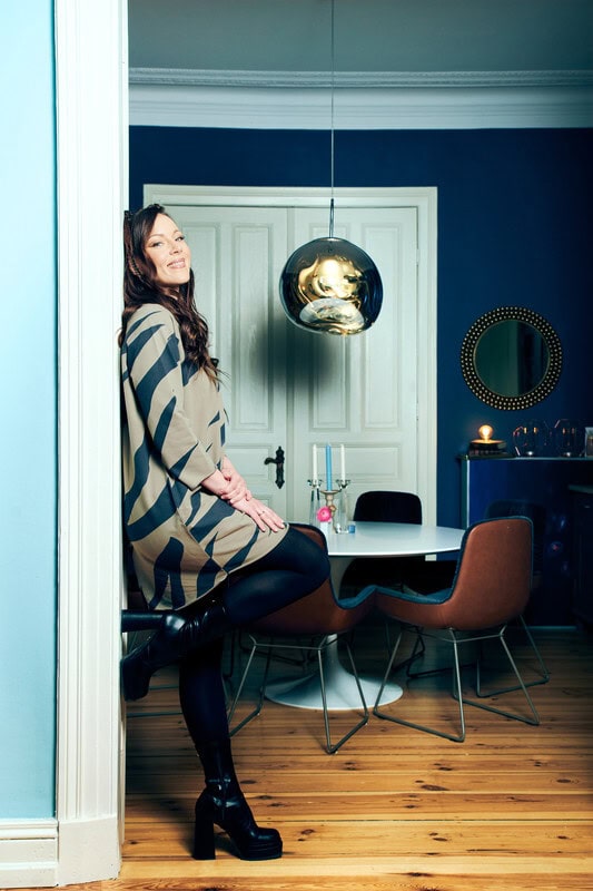 Jasmin Wagner leht an einer Wand und winkelt ein Bein dabei an.