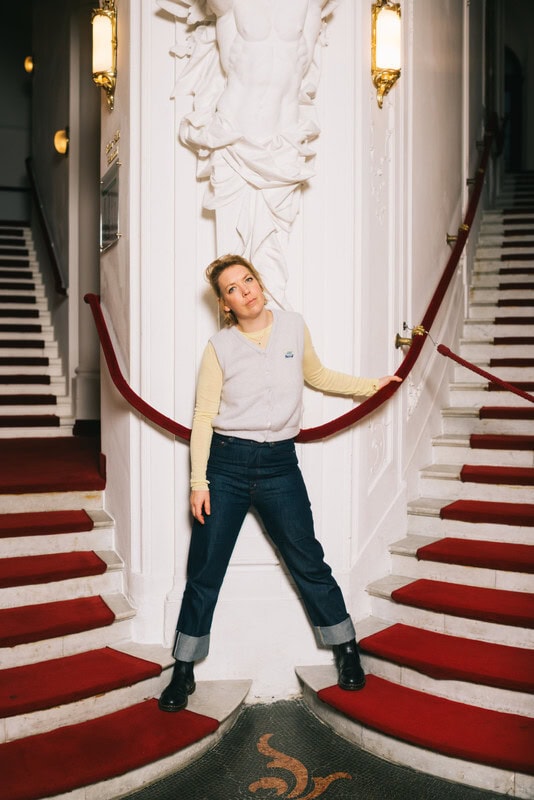 Lina Beckmann steht zwischen zwei Treppen im Theater