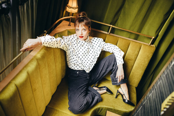 Portrait von Jella Haase, die auf einer grünen Couch sitzt, von oben fotografiert